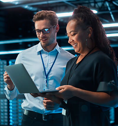Professionnels IT analysant des données sur ordinateur dans un centre de données, illustrant la gestion des infrastructures numériques et des réseaux sécurisés